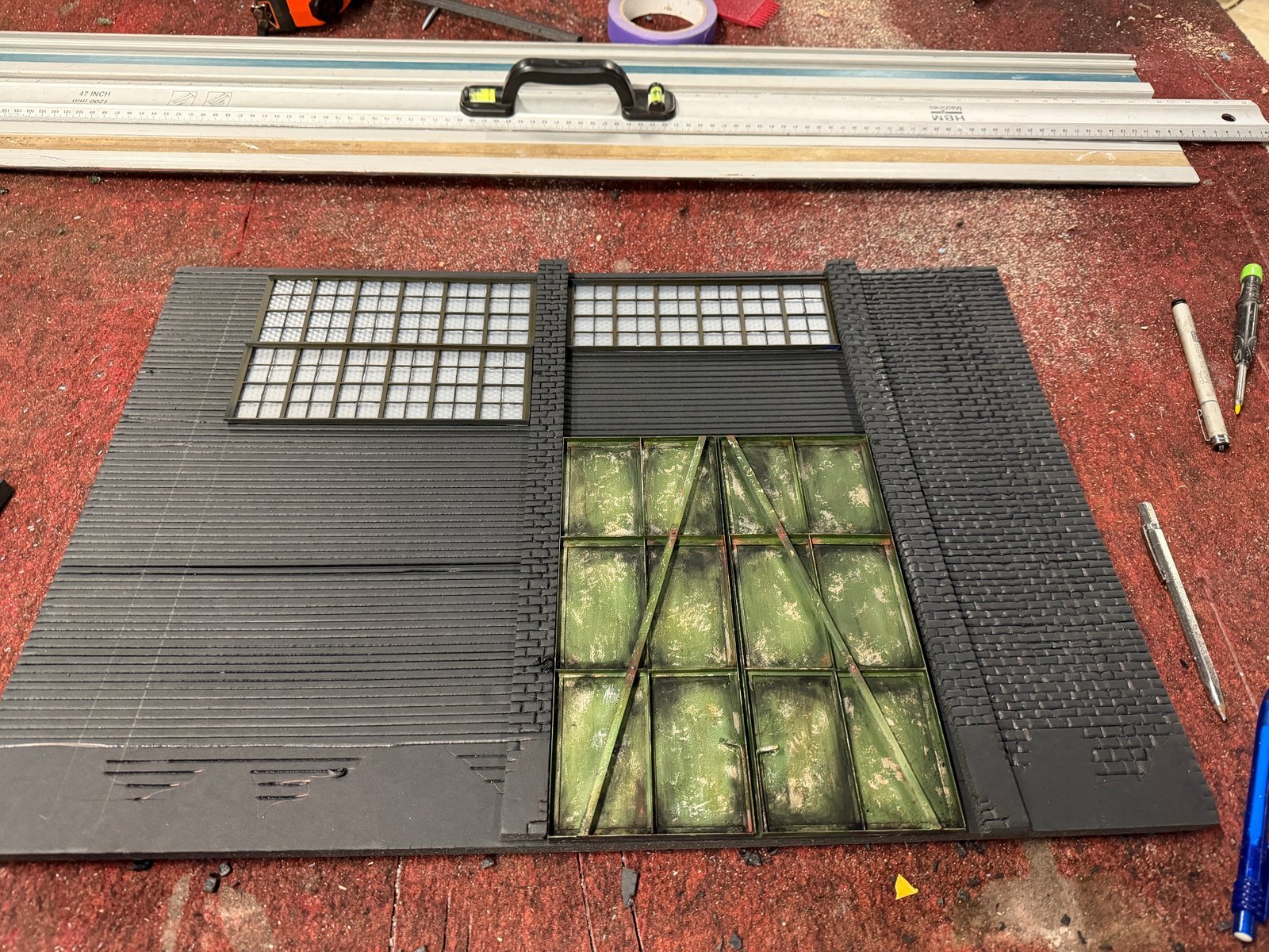 Foam brick walls for 1:24 scale Mad Max garage diorama showing hand-carved foam sheets with grid windows before painting