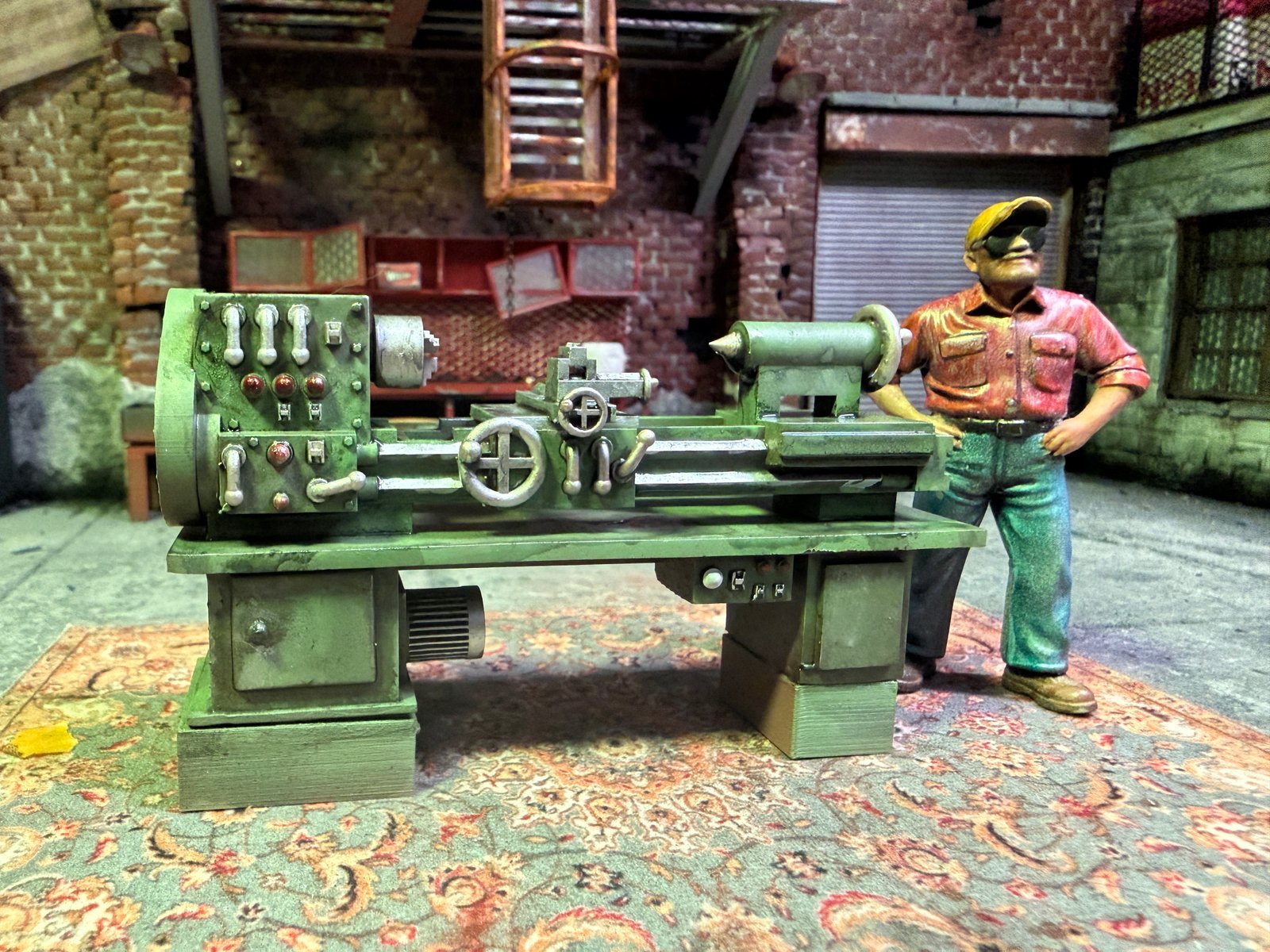Close-up of 1:24 scale metal lathe machine model beside a painted mechanic figure in the Mad Max garage diorama
