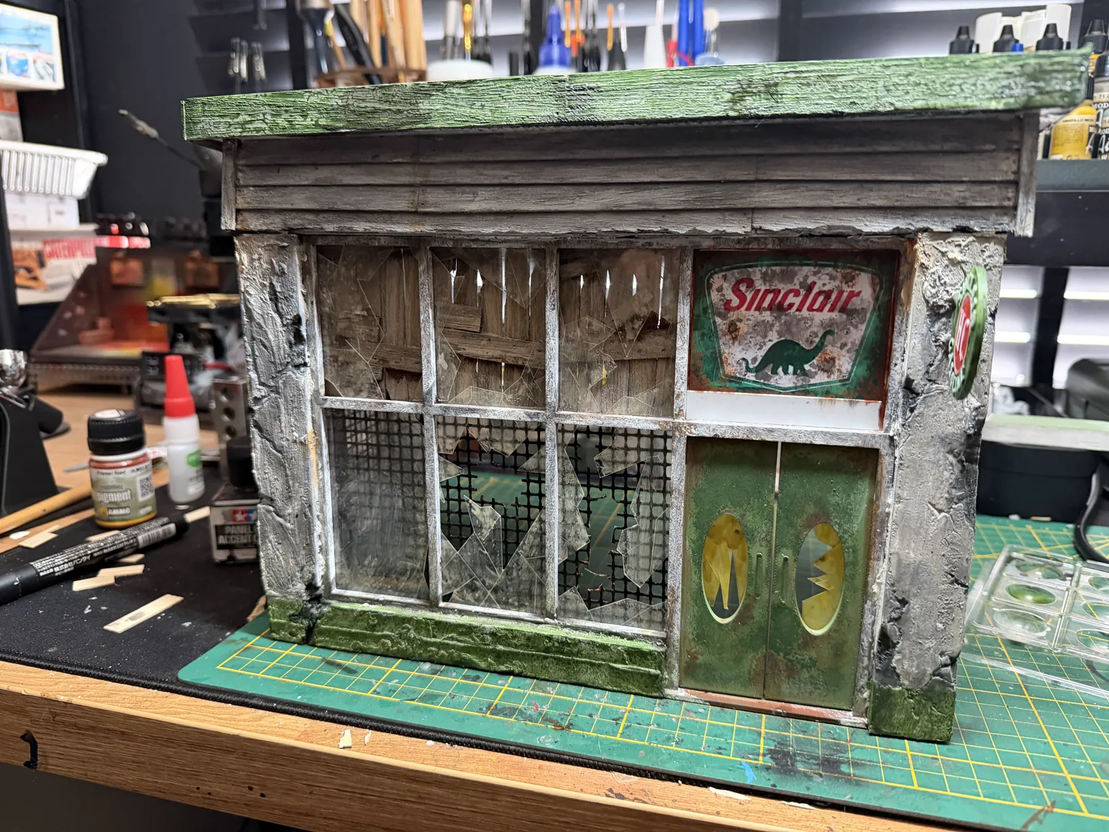 Front of the gas station with weathered walls and green doors