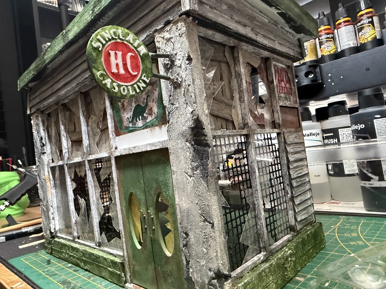 The office corner with its round gas station sign, broken windows and green doors