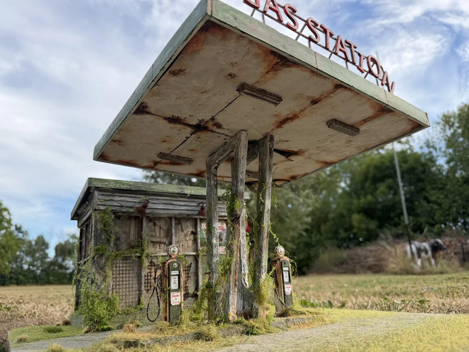 The finished gas station outside, with weeds growing up the canopy posts
